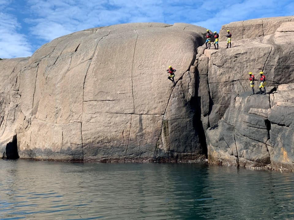 Large cliff jump coasteering in Norway in the Unesco Magma coastal Geopark.