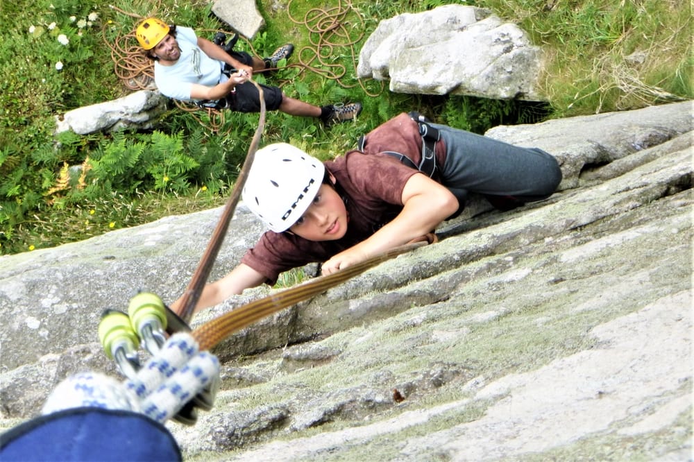 Young rock climber on a beginner rock climbing course at Trewavas Head near Penzance, Cornwall.