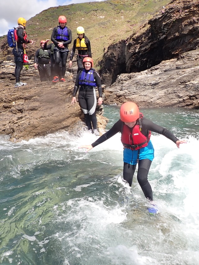 Enjoying all the coastal features on a beginner coasteering trip at Praa Sands, Cornwall