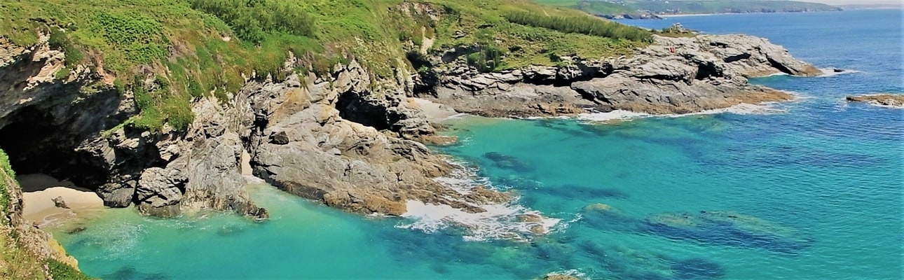 Prussia Cove caves with Praa Sands in the background. Photo by Kernow Coasteering