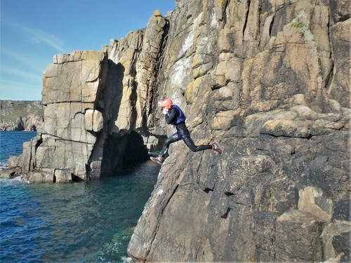 Coasteering at Land's End. Large cliff jump near the First and Last House, Land's End, Cornwall, UK./