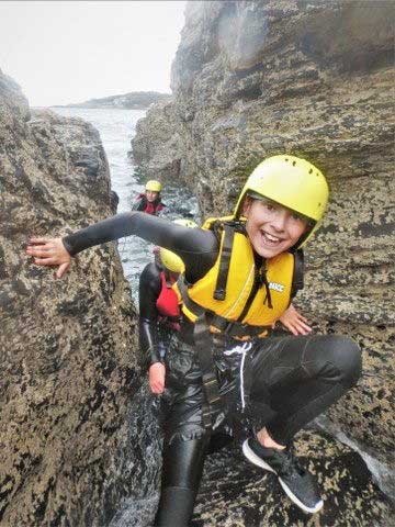 Coasteering is suitable for all ages and abilities. Here a young boy is coasteering with Kernow Coasteering in Cornwall.