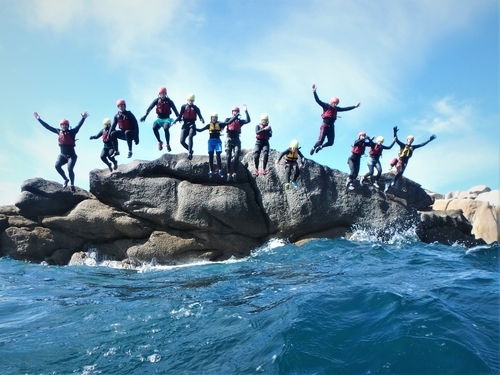 Large group jumping at Peninnis Head. Bes adventure things to do on Scilly. Coasteering on St. Mary's at Peninnis Head Kernow Co