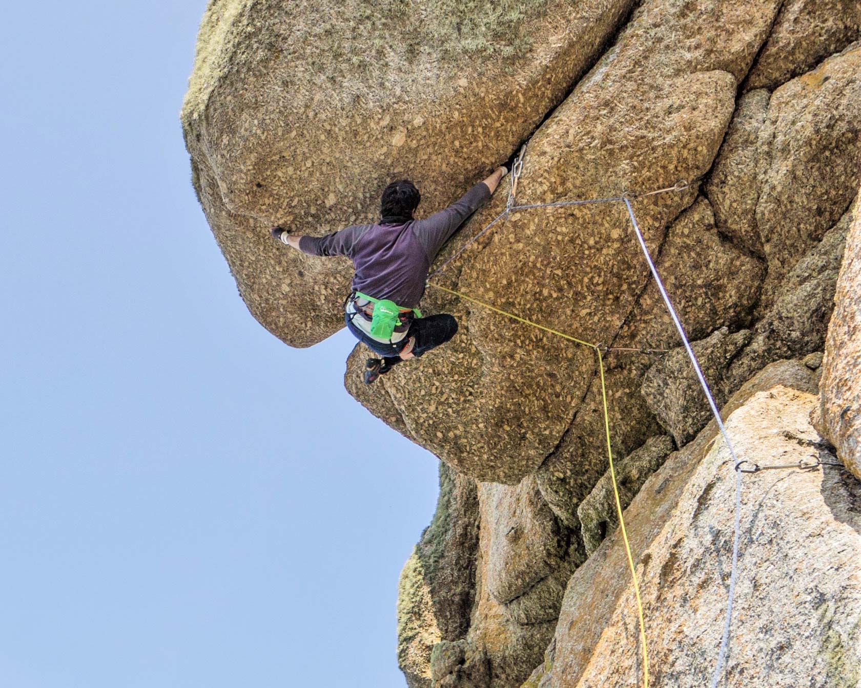 Climber on Superjam at Sennen, Cornwall. A wide roof crack test piece