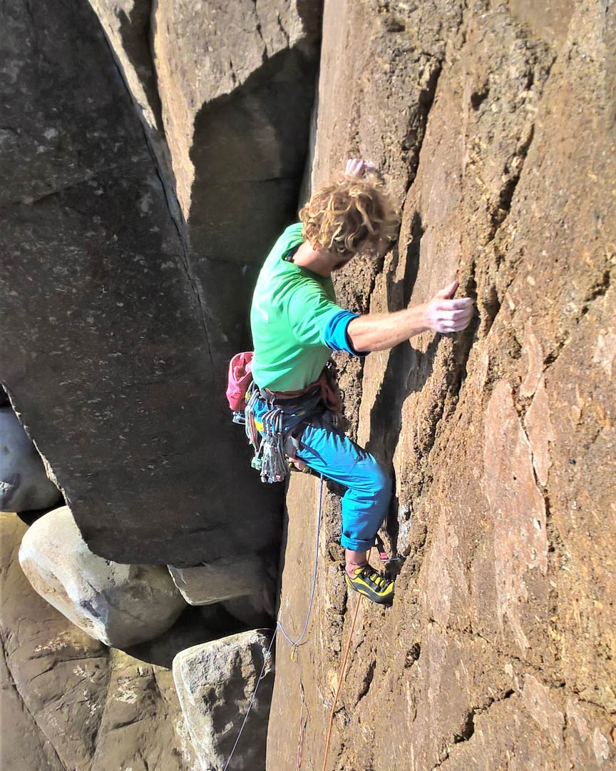 Climber on the steep wall of Grand Plage, E3, at Carn Barra, Cornwall.