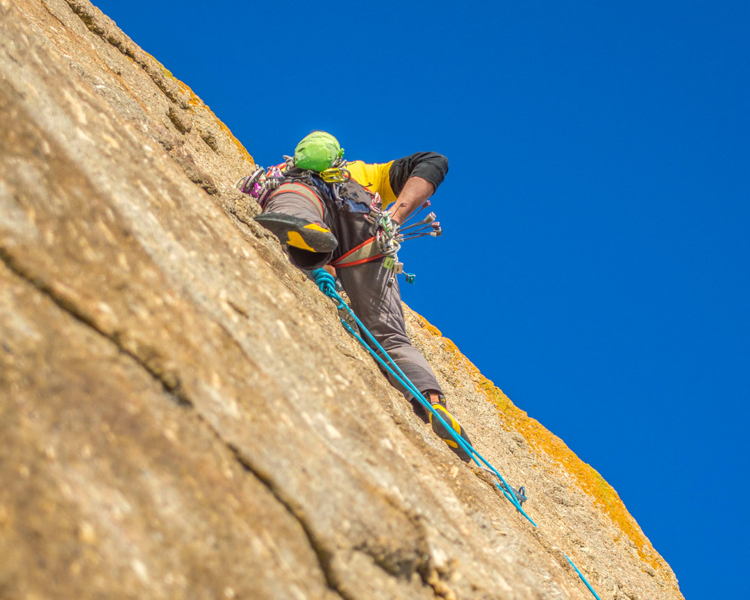 Male climber on a traditional rock climb at Carn Boel, Cornwall. The route is Hands of Stone, E2