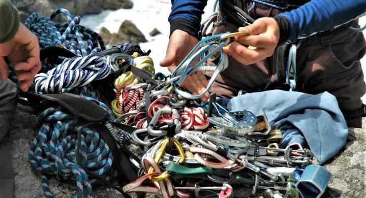 Two climbers prepare their equipment ready to do a multi pitch trad climb at Bosigran, Cornwall, UK