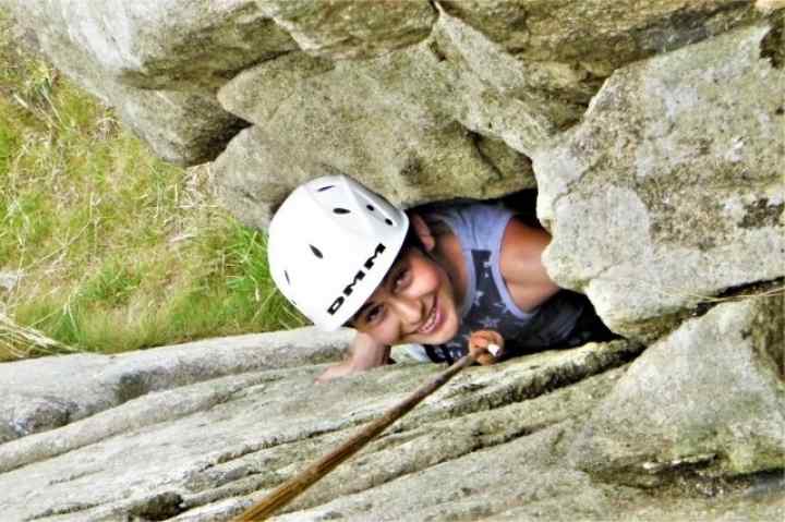 Young rock climber on a beginner rock climbing course in Cornwall with Kernow Coasteering. Rock climbing the groove at Trewavas 