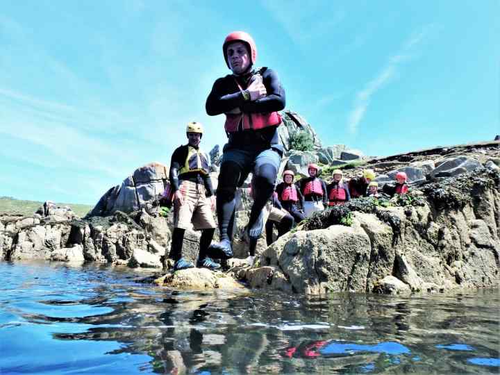 Start of a coasteering session on Isles of Scilly. Coasteering group at St. Mary's jumping into water at Peninnis Head. Best act