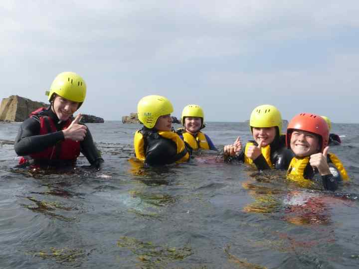 Cornwall's best adventure day's out. Activities for all the family. Here a group of young people are enjoying coasteering near S