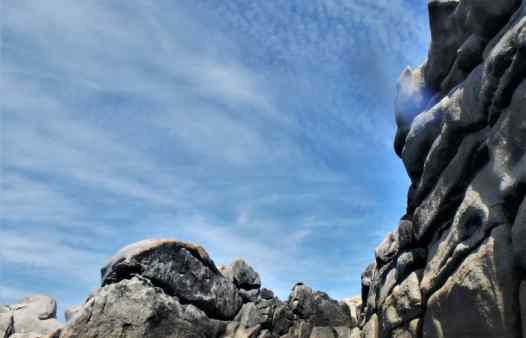 Coasteering guide doing a massive cliff jump on the Isles of Scilly