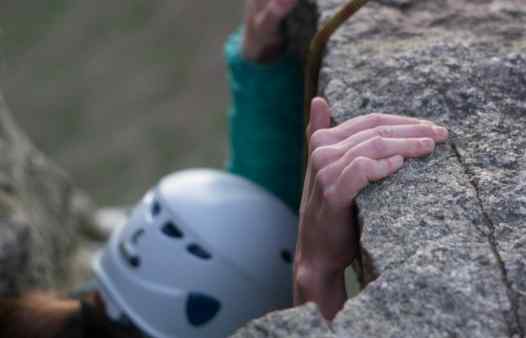 Climber at Trewavas in Cornwall, close up of fingers pulling hard on a rock hold.