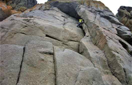 Rock Climber on pitch 1 of Diocese, a classic rock climb in Cornwall