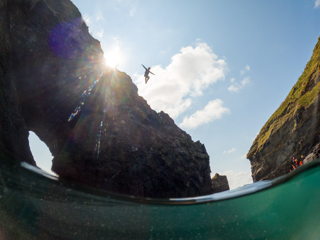 Coasteerer jumping from Lazy Bank Island into deep water at Praa Sands