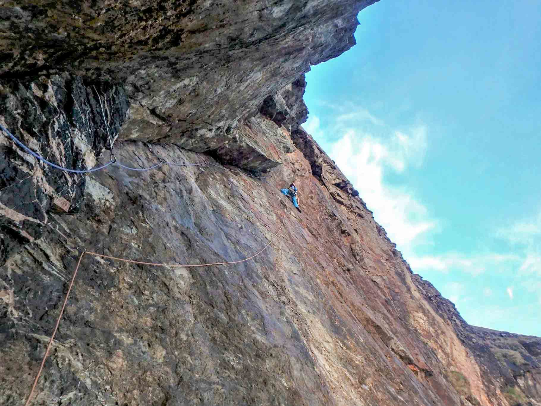 Climber on Mercury (E2) at Carn Gowla, Cornwall, using half ropes to protect a long, exposed traverse.