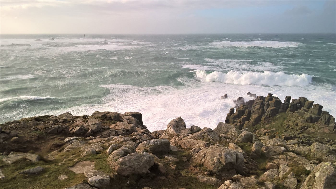 Huge storm waves crashing into the granite cliffs at Land’s End, shaping the sea caves in Cornwall.