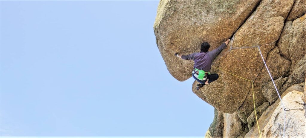 Climber on Superjam (E5), an inverted off-width crack at Sennen, Cornwall – demonstrating advanced trad climbing techniques