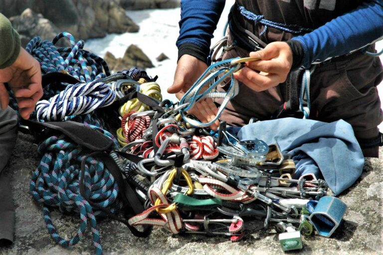 Two climbers prepare their equipment ready to do a multi pitch trad climb at Bosigran, Cornwall, UK