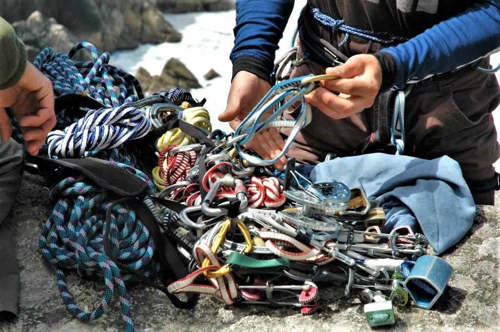 Two climbers prepare their equipment ready to do a multi pitch trad climb at Bosigran, Cornwall, UK
