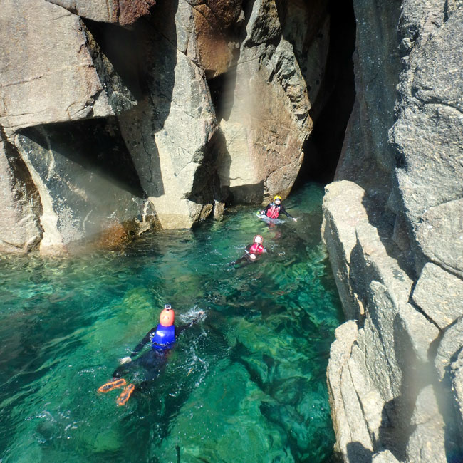 Coasteerers swim into a dark surge-filled tunnel at Land’s End’s infamous Ghost Train