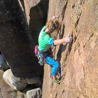 Experienced climber tackling steep granite walls on an advanced outdoor climbing Cornwall course with Kernow Coasteering.