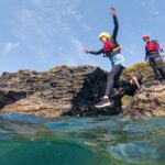 Children and parents coasteering in Cornwall — one of the top things to do with kids in Cornwall