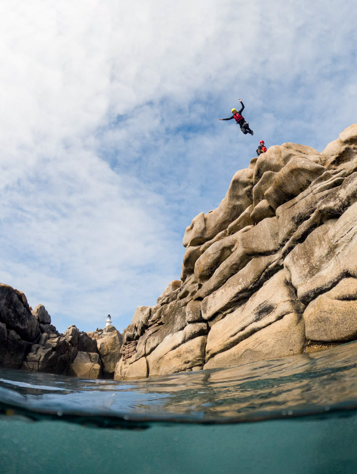 Brave adventurer soaring off the biggest jump at Peninnis Head Lighthouse, near Hugh Town, Isles of Scilly.