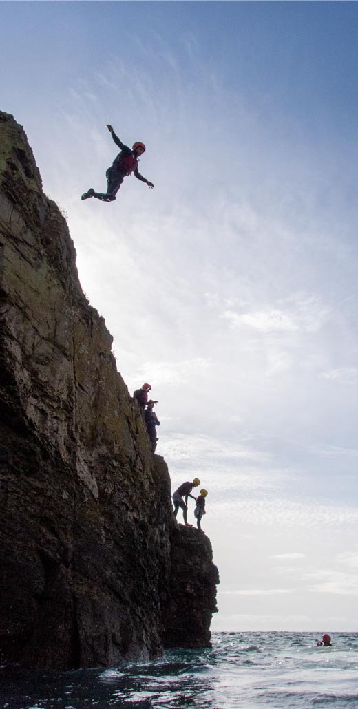 Big coasteering jump at Praa Sands, Cornwall – one of Kernow Coasteering’s signature thrill moments
