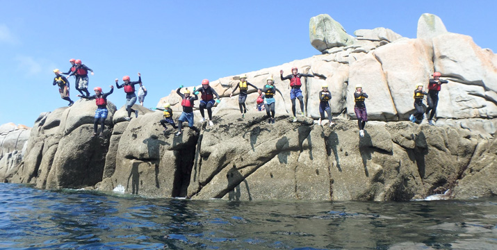Group jumping off the 'party jump' together on St Marys Scilly