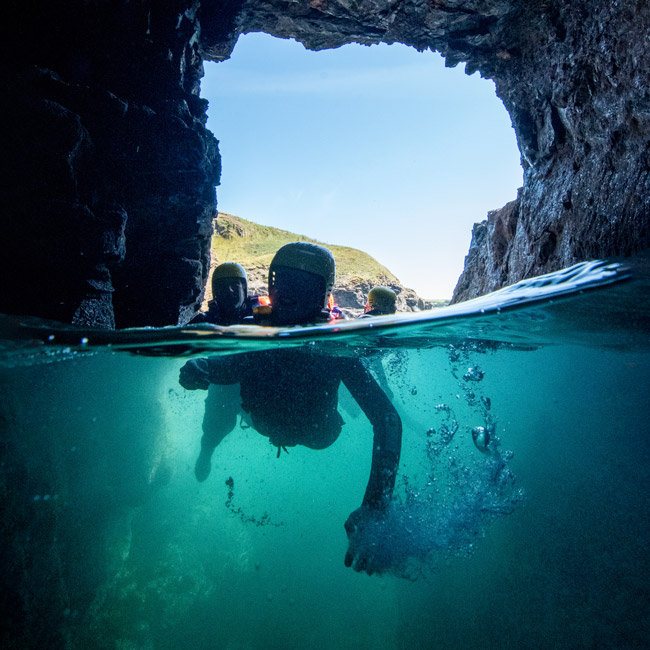 Exploring sea caves and natural rock tunnels near Praa Sands on a guided Cornish coasteering route.