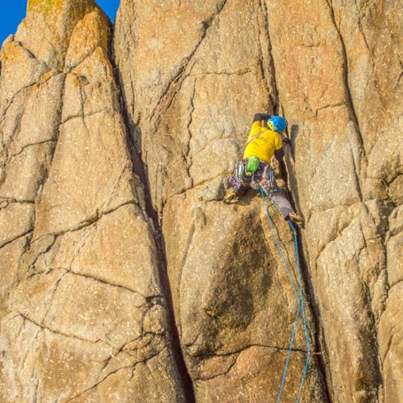 Climber on a steep rock face during a guided climbing Cornwall experience designed for advanced climbers