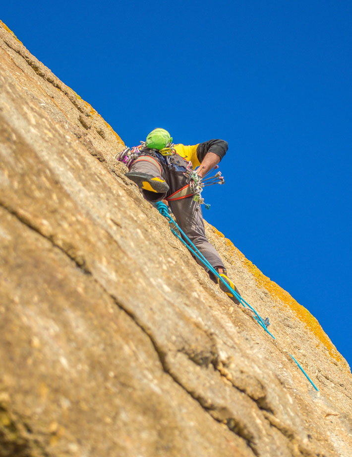 Climber on granite sea cliffs showcasing why Cornwall climbing offers some of the best rock climbing experiences in the UK.