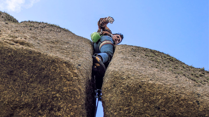 Kernow Coasteering instructor climbing the E4 route Jack Yer Body at Logan Rock, Cornwall