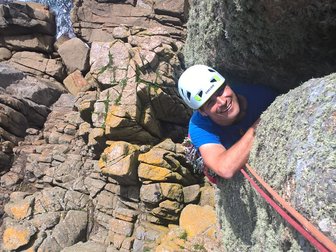 Climber smiling as he ascends a multi-pitch climb at Chair Ladder