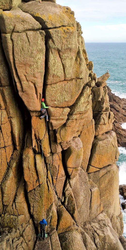 Climbers ascending the off-width crack of Seahorse HVS 5b at Chair Ladder, Cornwall.