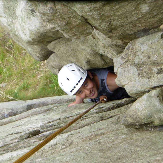 Young climber tackling a beginner-friendly granite crack at Trewavas Head
