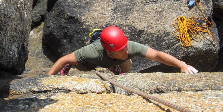 Trad climber leads the bold wall of Catholic Girls (HVS) at Sennen on a bright Cornish day.