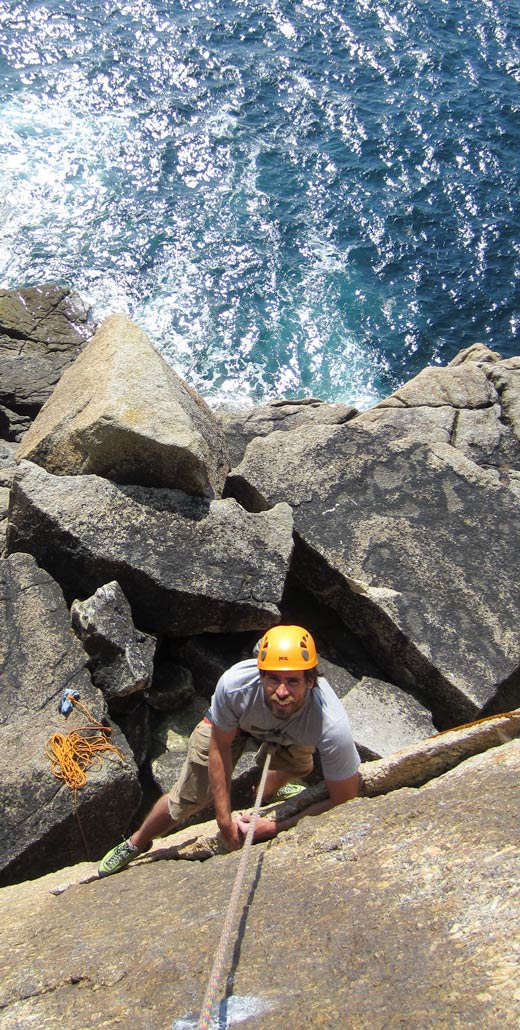Climber making moves on Catholic Girls, an exposed HVS trad line above the sea at Pedn-men-Du.