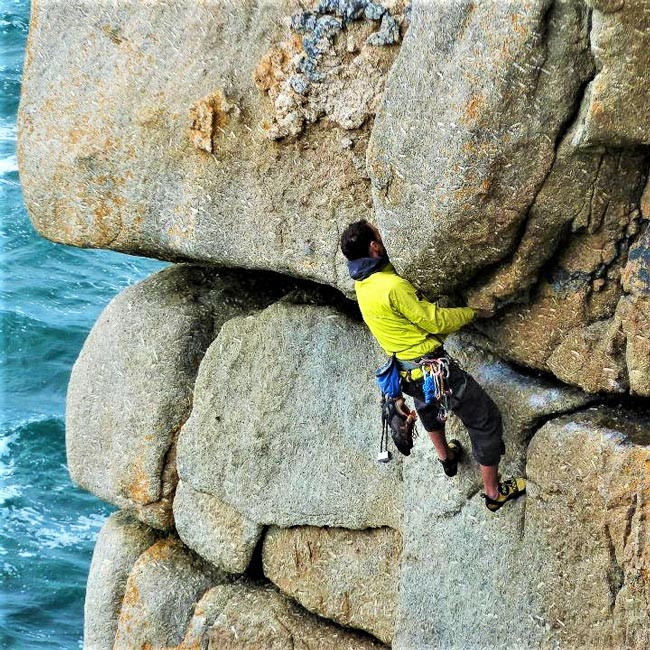 Climber on Demo Route at Sennen, a classic granite line high above the sea