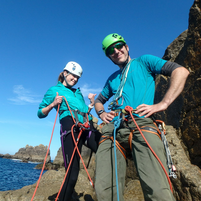 Instructor and climber preparing for guided sea cliff climbing on Red Wall, HS 4b, at Chair Ladder, Cornwall.