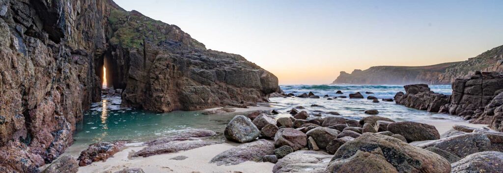 Sunset light shining through the sea cave at Nanjizal Beach, Cornwall